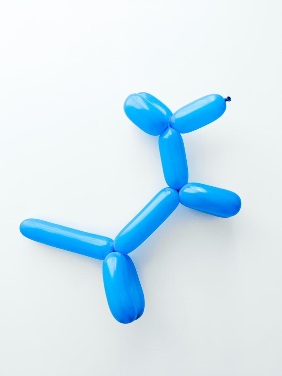 A blue balloon animal in the shape of a dog.