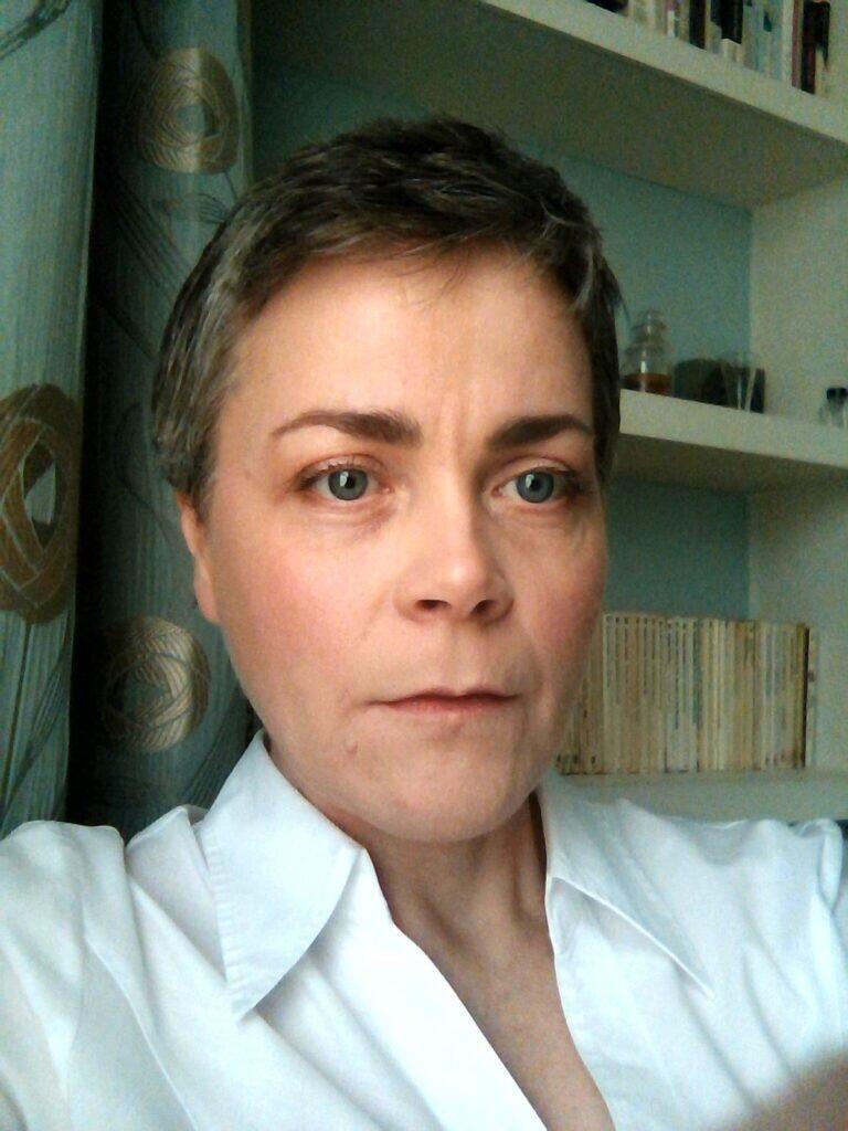 A woman with short hair is looking at the screen.