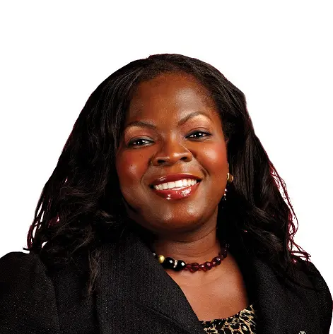 A woman with long black hair is smiling towards the camera.