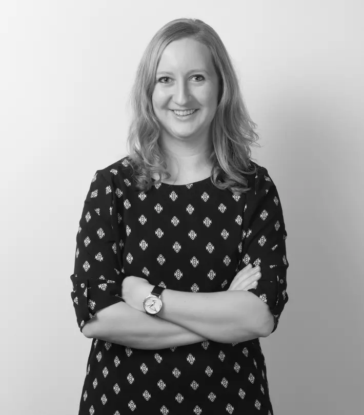 A black and white image of a woman with her arms crossed across her chest.