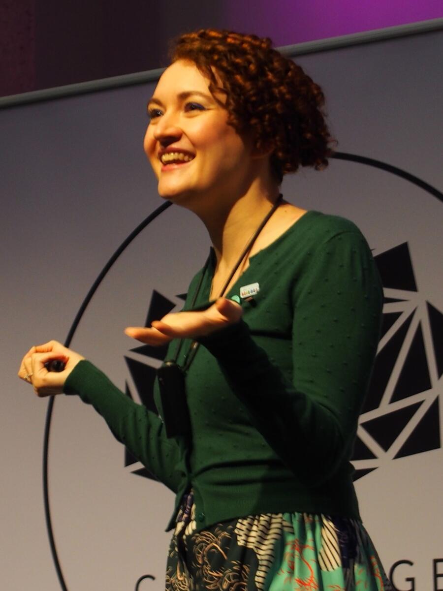 Ginny smiles and talks to an audience