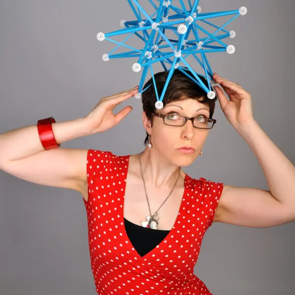 A woman is posing with an object on her head.