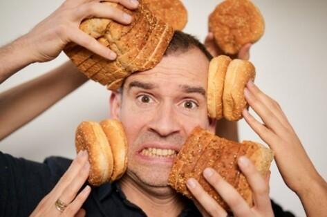A man is being attacked by bread.