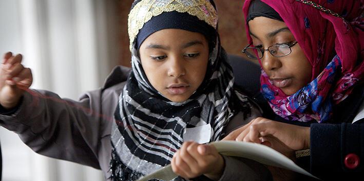 Two girls focussing on an activity on paper
