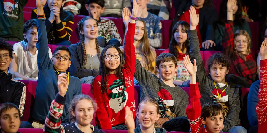 Children in the Christmas Lectures audience raising their hands