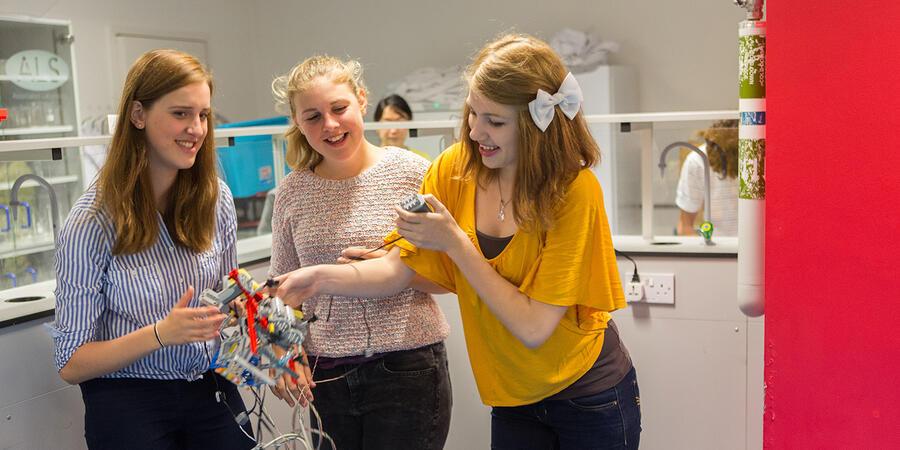 Three young ladies working on an electronics activity