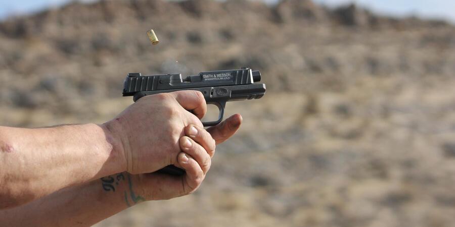 A person firing a handgun with two hands