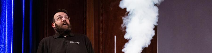 A man looking excited watching a demo with lots of smoke