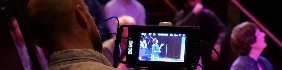 A person filming a talk in the Ri Theatre