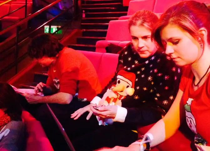 2014 Christmas Lecturer Danielle George in a Christmas jumper sitting next to Michelle in a Christmas T-shirt looking at a laptop screen intently