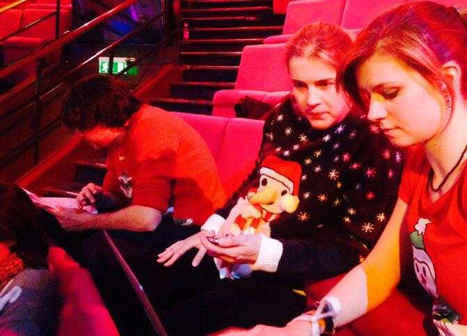 2014 Christmas Lecturer Danielle George in a Christmas jumper sitting next to Michelle in a Christmas T-shirt looking at a laptop screen intently