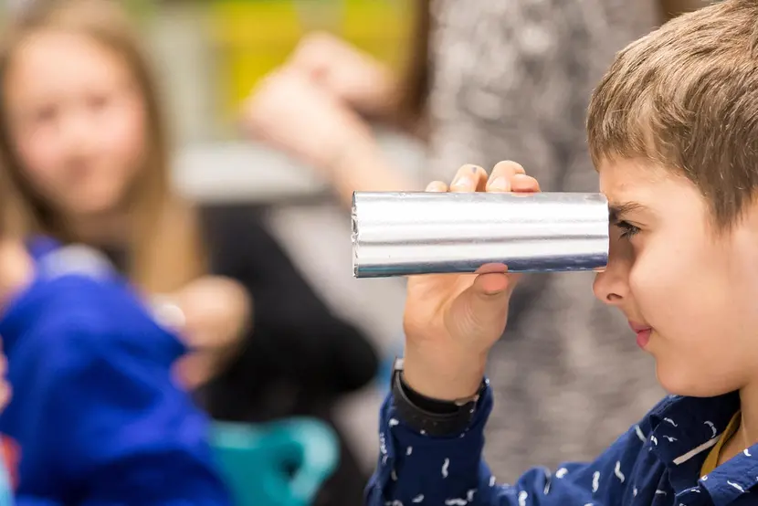 boy looks through a foil tube