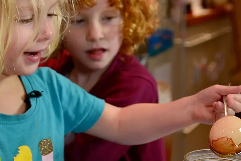 two little girls lifting an egg with a spoon