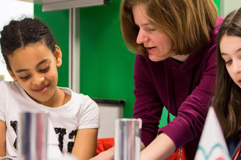 children and woman doing a science experiment