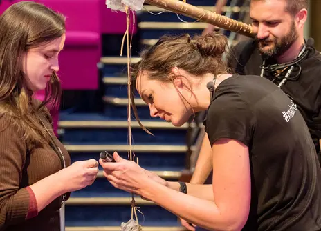 three people working on a theatre prop