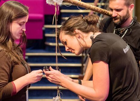 three people working on a theatre prop