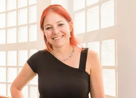 Alice roberts standing in front of a window