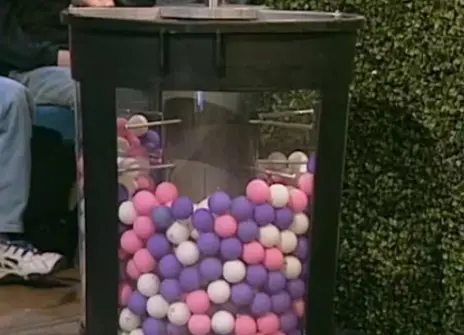 A clear cylinder filled with coloured balls