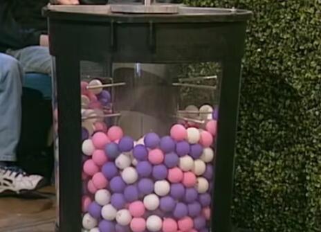 A clear cylinder filled with coloured balls