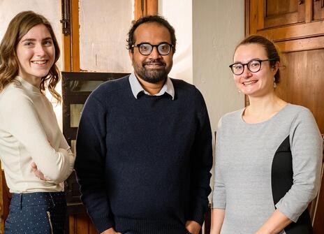 three people stand in the Faraday Lab at the Ri