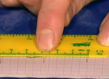 A yellow ruler being used on graph paper