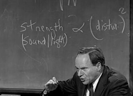 Philip Morrison speaking in front of a chalkboard