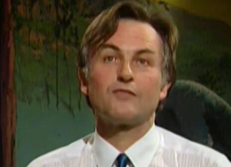 Richard Dawkins speaking in front of a dark green backdrop