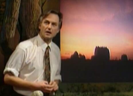 Richard Dawkins speaking in front of a dark green backdrop