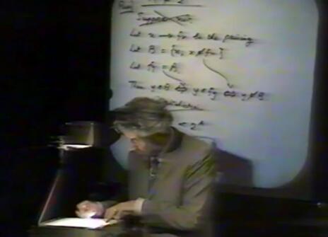 Christopher Zeeman writing equations using a projector in the Ri theatre
