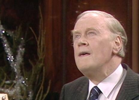 RV Jones speaking in the Ri Theatre, with a christmas tree in the background