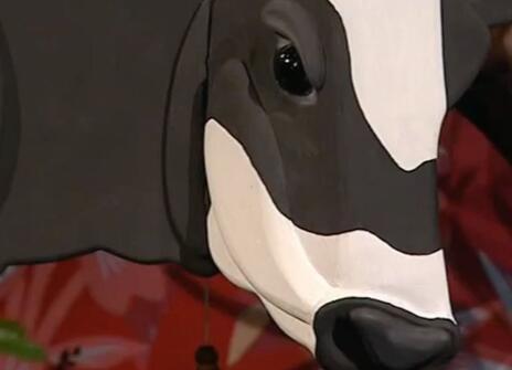 A sculpture of a black and white cow