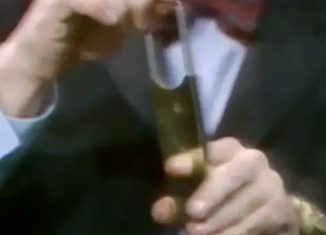 Heinz Wolff putting his finger in a contraption that looks like a cigar cutter