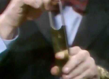 Heinz Wolff putting his finger in a contraption that looks like a cigar cutter