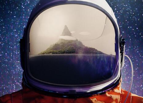 astronaut with a reflection of a mountain peak in the visor
