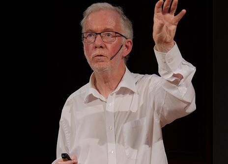 Brian Clegg in a white button up shirt in the Ri lecture theatre