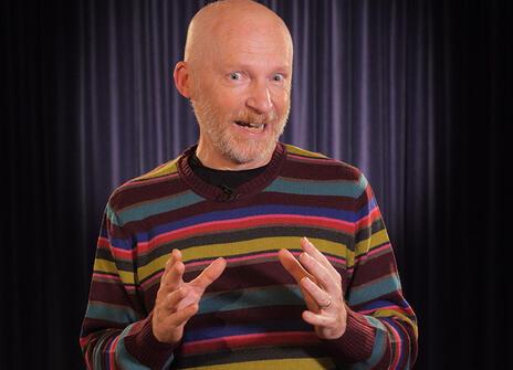 Marcus du Sautoy in a stripey jumper gesticulating at the camera