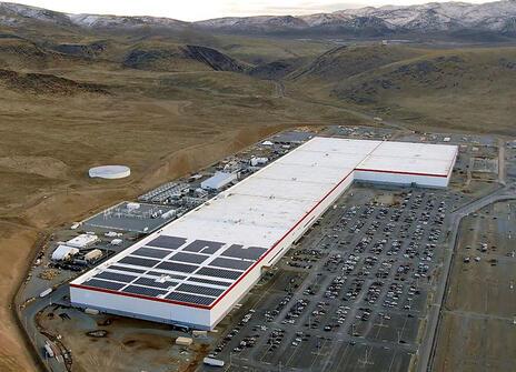 One of Tesla's gigafactories, an aerial view of a giant L shaped boxy building