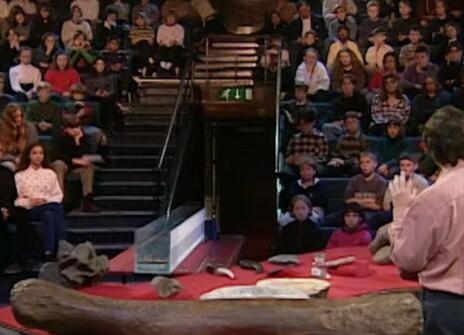 Simon Conway Morris speaking to a crowd of seated children in the Ri theatre