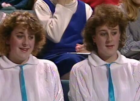 A set of women twins dressed in identical white shirts and blue ties