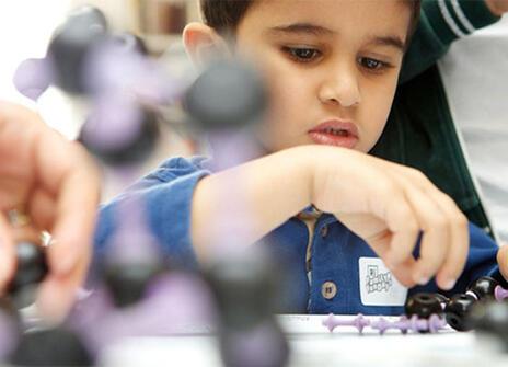 A child handling a molecule model