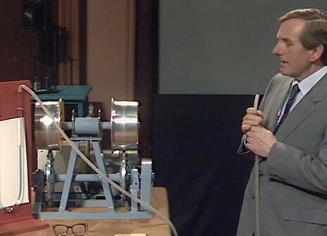 Leonard Maunder holding a rubber tube that is linked to two glass tubes