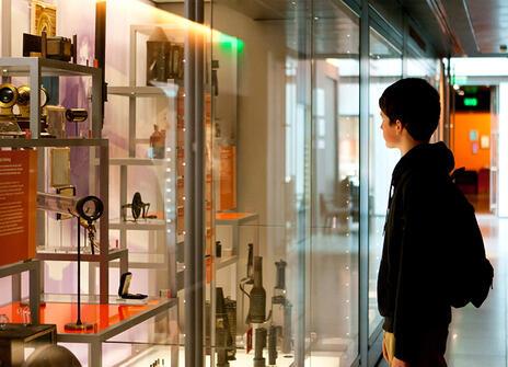 A child looking into the display cases of the Faraday museum