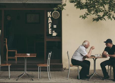 Men conversing outside a house