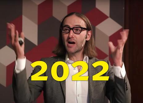 A still from James Beacham's 2022 Ri Talk. The number 2022 is placed between his hands