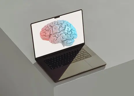 A laptop with a digital illustration of a brain on screen