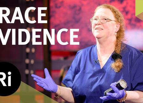 Professor Dame Sue Black, dressed in blue scrubs, has her hands slightly raised. Overlayed are the words 'TRACE EVIDENCE' along with the Royal Institution Logo.