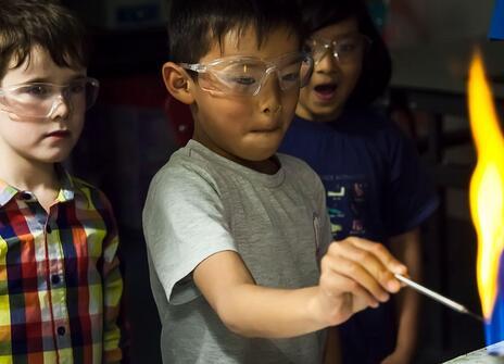 Children looking at a flame during a family fun day