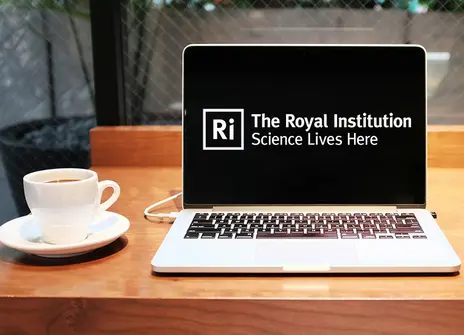 A laptop on a table showing the Ri logo