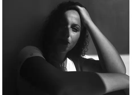 A women looks into the camera in a black and white image