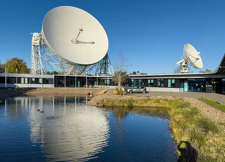 Parabolic dishes at Jodrell Bank, reflected in water